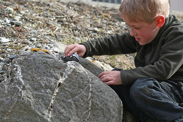 Un petit garçon joue aux petites voitures