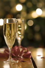 champagne flutes at the light of a christmas tree