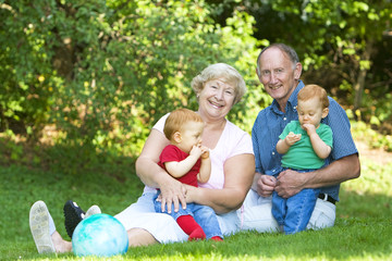 Happy handsome grandparents with twin grandsons outdoor portrait