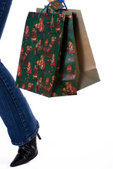 Woman carrying gift bags with holiday prints on white