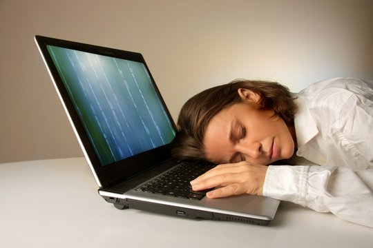 a woman sleeps on a laptop