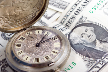 Pocket watch and dollars.counting out of time