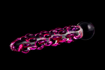 glass dildo with raised pink patterns on black background