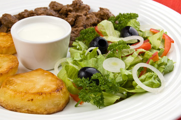 Grilled meat with baked potatoes, sauce and vegetable salad