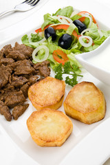 Grilled meat with baked potatoes, sauce and vegetable salad