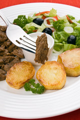 Grilled meat with baked potatoes, sauce and vegetable salad