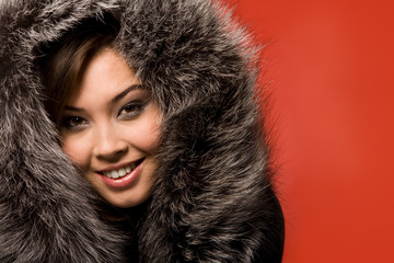 Face of beautiful girl in fur-cap looking at camera with smile