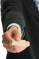 Businessman handing over his business card. Focus on the card. .