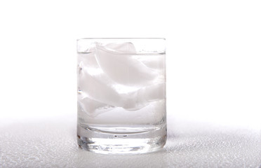 A clear glass of ice water or beverage on a white background