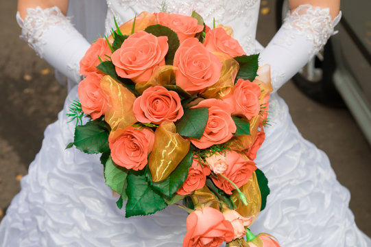 red rose bouquet in girls hand after wedding
