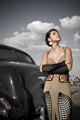 Fototapeta na wymiar Pretty girl in exclusive woolen dress near the vintage car.