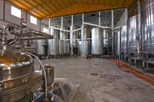 Vino fermentando en enormes tinas en una bodega en Espa&ntilde;a