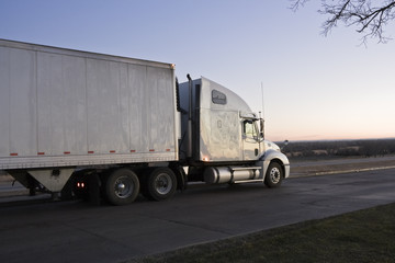Fototapeta na wymiar Wschód słońca jazdy - Semi-Truck na drodze.