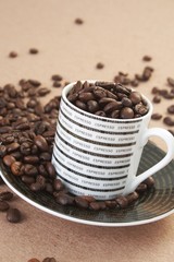 cup filled with roasted coffee beans on a table