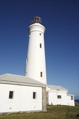 sideview of a brilliant white lighthouse in the late afternoon