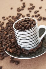 cup filled with roasted coffee beans on a table