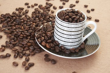cup filled with roasted coffee beans on a table