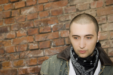 Rapper boy posing at a brick wall, urban scene