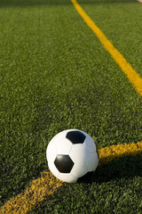 A soccer ball or football on a soccer field positioned