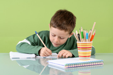 7 years old boy doing his homework - education