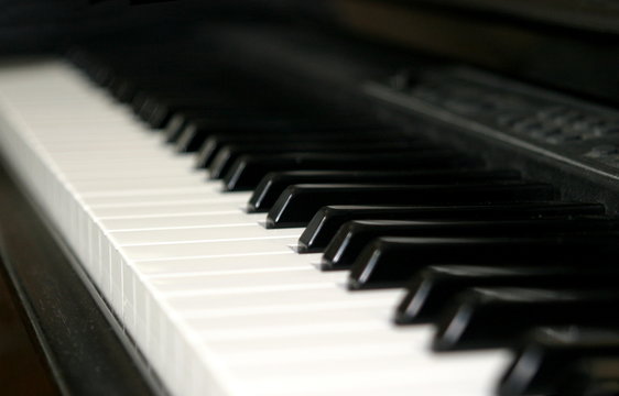 Black and white piano keyboard from an angle.