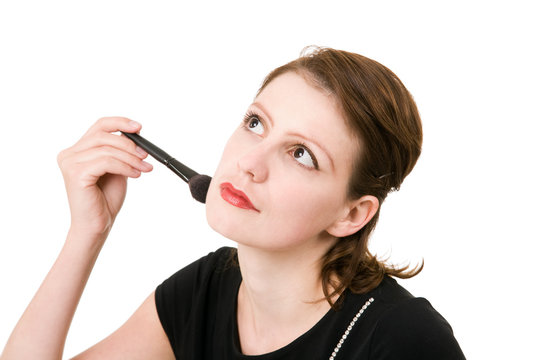 portrait of young beautiful dreaming woman with a cosmetic brush