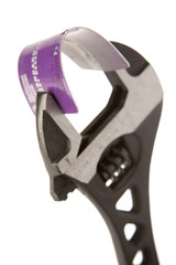 Credit card held in wrench against white background