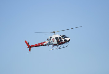 TV-news helicopter in flight with a cameraman shooting