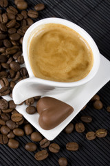 Cup of creamy espresso with coffe beans