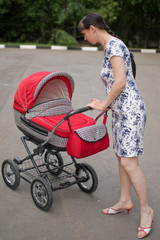 Young woman with red baby carriage