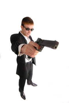man in  black suit with a pistol in  hand