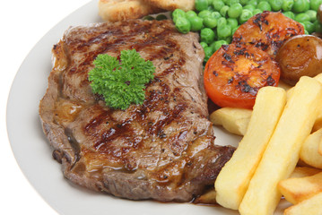 Sirloin steak with chips, peas, tomato and onion rings