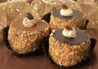 Three miniature chocolate meringue cakes with cream