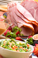 Holiday table setting with delicious whole baked sliced ham