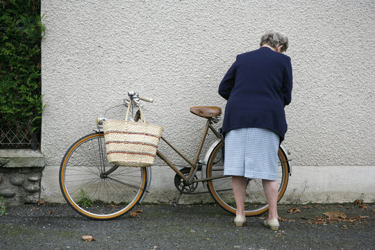 Old lady with bicycle in Argentat market , Correze, France