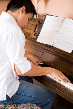 A Shot Of An Asian Man Playing Piano