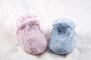 A pair of pink and blue baby shoes on a white background.