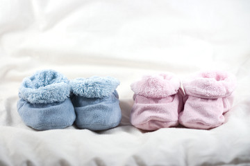 A pair of pink and a pair of blue of cute baby shoes - obrazy, fototapety, plakaty