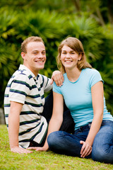 A young couple sitting outside in park or garden
