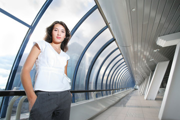 Confident young businesswoman in futuristic interior.