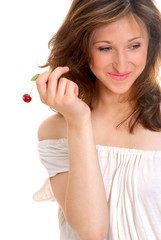 Portrait of a beautiful young girl holding a cherry in her hand