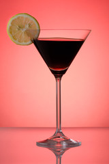 Cocktail with lemon slice on re background