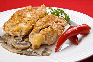 Stuffed fried chicken fillets with cheese, ham, and vegetables