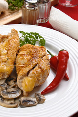 Stuffed fried chicken fillets with cheese, ham, and vegetables