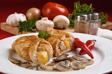 Stuffed fried chicken fillets with cheese, ham, and vegetables