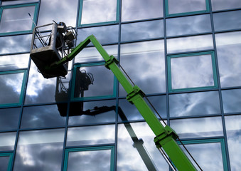 Window cleaner working on a glass facade in a gondola - 9943477
