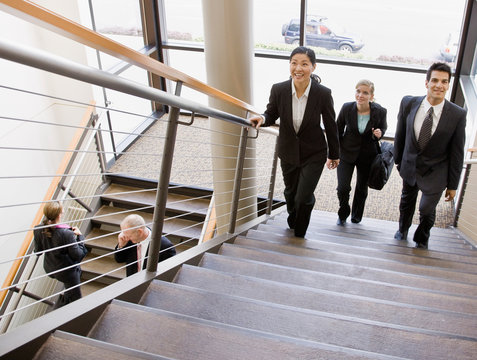 Multi-ethnic co-workers ascending office stairs