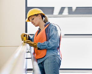 Construction worker taking measurement with measuring tape