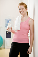 Naklejka premium Fatigued woman drinking bottle of water after work out