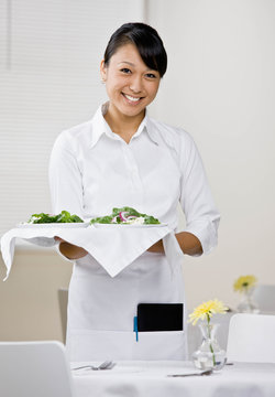 Waitress serving healthy salad for lunch in elegant restaurant